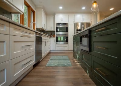 A kitchen with white cabinets and green counter tops.