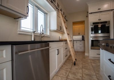 A kitchen with a ladder and stainless steel appliances.