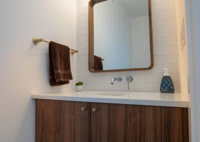 A bathroom with a wooden vanity and mirror.