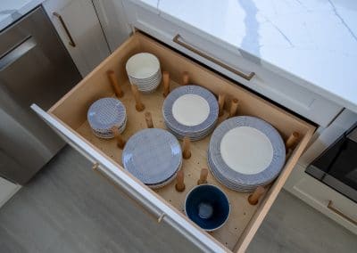 A drawer full of plates and bowls in a kitchen.