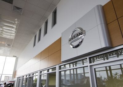 A nissan dealership with a sign on the front door.