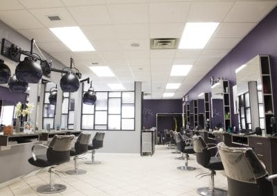 A hair salon with purple walls and chairs.