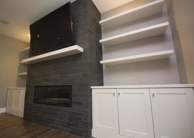 A fireplace with built in shelves and a tv above it.