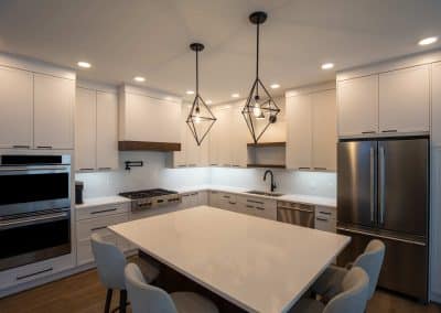 A modern kitchen with white cabinets and stainless steel appliances.